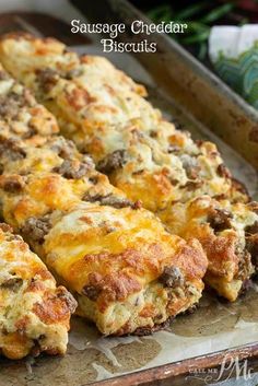 sausage cheddar biscuits on a baking sheet with cheese and meat in the middle