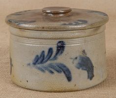 a blue and white container with a bird design on the lid sitting on a beige surface