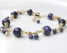 Gorgeous sapphire bracelet features genuine sapphire gemstones finely faceted for added sparkle. Swarovski crystals in champagne and more real sapphire gemstones dangles to add movement to this luxe artisan bracelet. 14k gold filled findings. Give a precious gift to a beautiful woman born in September since sapphire is her birthstone. Dressy bracelet can be worn to formals, events and everyday.Bracelet Details:- Bracelet is 7 to 8.5 inches long (17.78 cm to 20.32 cm)- A built in extender to all Elegant Sapphire Bracelets With Faceted Beads, Elegant Sapphire Faceted Bracelets, Elegant Sapphire Bracelet With Faceted Beads, Sapphire Gemstone Bracelets For Wedding, Sapphire Faceted Jewelry For Anniversary, Faceted Sapphire Jewelry For Anniversary, Faceted Tanzanite Jewelry For Anniversary, Elegant Beaded Bracelets With Birthstone For Wedding, Elegant Crystal Bracelet With Birthstone For Anniversary