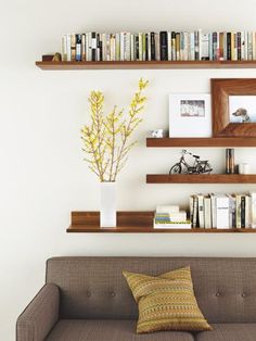 a living room filled with furniture and bookshelves next to a wall full of books