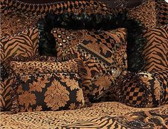 an animal print bed spread with pillows and blankets on it's side, in front of a white background