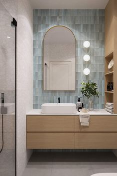 a bathroom with two sinks and a large mirror above the sink is illuminated by three lights