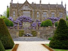 a large building with purple flowers on it's walls and steps leading up to the entrance