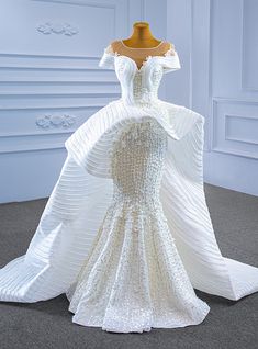 a white wedding dress on display in a room