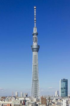 a very tall tower towering over a city filled with lots of tall buildings in the distance