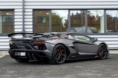 a grey sports car parked in front of a building