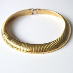 Quality Vintage 1980s Chunky Omega 16" Collar Necklace.  Gold Tone with Flip Over Clasp.  Hollow coiled flexible omega links that have a slight stretch to them. This has been finished in alternating smooth shiny and lightly textured bands, giving this a slightly stripy look.  This looks like real Gold and could actually be Gold plated, but as it is untested we are only stating Gold tone.  Length approx. 395mm ( 15 1/2"), un-stretched. 15mm wide x 5mm thick.  There are no makers marks on this nec Retro Gold Adjustable Choker, Gold Retro Choker, Gold Tarnish-resistant Choker, Thick Choker Necklace, 80s Necklace Vintage, 80s Gold Earrings, Collar Necklace Gold, Pierre Cardin, Choker Necklaces