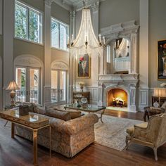 a large living room with two couches and a chandelier in the center