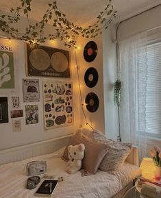 there is a bed with many pictures on the wall above it and a teddy bear