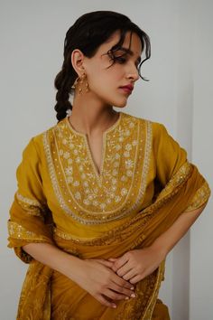 Mustard organza saree with aari hand embroidery. Comes with a blouse.
Components: 2
Pattern: Hand embroidered
Type Of Work: Aari
Neckline: Notched
Sleeve Type: Half
Fabric: Organza
Color: Yellow
Other Details: 
Note : Outfit worn by the model on the right is not for sale.
Occasion: Sangeet - Aza Fashions Navratri Organza Blouse With Dupatta, Transitional Organza Salwar Kameez With Cutdana Details, Organza Kurta With Zari Work For Reception, Gold Embroidered Georgette Blouse Piece, Gold Georgette Blouse With Intricate Embroidery, Yellow Blouse Piece With Intricate Embroidery In Traditional Drape, Anarkali Embroidered Georgette Blouse, Gold Intricate Embroidery Blouse In Georgette, Traditional Organza Kurta With Intricate Embroidery