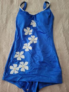 This is a very nice 1960 Blue swim suit with white daisy along the front. In very good vintage condition.  It is a very shapely bathing suit. Has adjustable buttons on strap.  Tag says size 12 however, this is in the 1960 and todays size would be a size 6.  It has a good tight stretch to it.   Any other questions please feel free to ask.  Thanks for stopping by 1970s Bathing Suits, Swim Tops For Large Bust, Vintage Blue Swimwear For The Beach, Gyaru Swimsuit, Blue Swimsuit Outfit, Aesthetic Bikinis 90s, Full Body Bathing Suit, 2000s Swimsuit, 2000s Swimwear