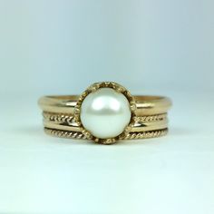 Classic and elegant, this vintage inspired pearl solitaire engagement ring exudes a timeless elegance with a simple band of gold set with a glowing pearl in a crown of hearts. Hand-wrought from recycled 14kt gold, a slim gold band holds a 6.5-7mm cultured creamy white freshwater pearl in a detailed 14kt gold filigree heart-crown setting. Pearl engagement rings are not only unique, but hold a special meaning as pearls symbolize wisdom, purity, harmony and loyalty. This ring would also make a love Pearl Engagement Rings, 14kt Gold Jewelry, Hearts Vintage, Filigree Heart, Pearl Engagement Ring, Heart Crown, Simple Band, Local Jewelry, White Freshwater Pearl