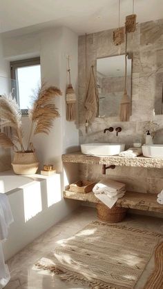 a bathroom with two sinks and towels on the counter, in front of a window