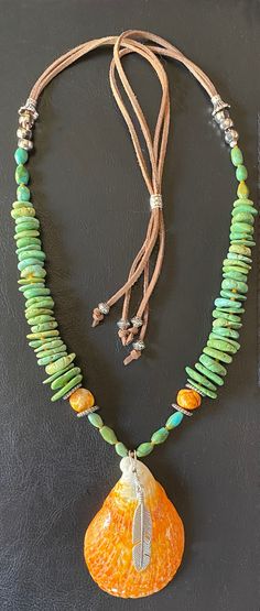 Feel the calming waves from the Sea of Cortez while wearing this stunning Spiny Oyster (Spondylid) Shell and marvelous green turquoise rondelle necklace. This hand polished oyster shell is base for a free hanging silver feather and shelters a sterling 1 inch Kokopelli charm hidden from view. Many believe this highly symbolic figure is associated with fertility, music, merrymaking and good luck.  This gorgeous Boho necklace can be adjusted to any length between 24 to 41 inches with soft light bro Southwestern Green Turquoise Necklace, Southwestern Green Beaded Necklaces For Festivals, Green Southwestern Beaded Necklaces For Festival, Southwestern Green Beaded Necklace For Festivals, Southwestern Green Jewelry For Beach, Southwestern Style Green Beach Jewelry, Adjustable Southwestern Green Turquoise Necklace, Southwestern Green Turquoise Necklace With Gemstone Beads, Bohemian Hand-strung Turquoise Necklace