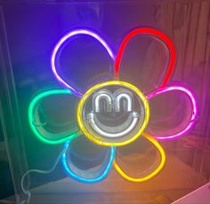 a neon flower with the letter m on it