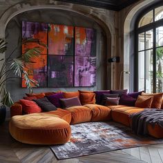 a living room filled with lots of furniture and large paintings on the wall above it