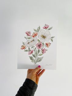 a person holding up a card with flowers on it