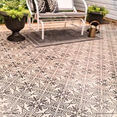 an outdoor patio with chairs and potted plants