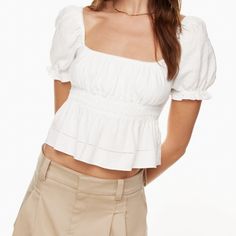 This Is A Smocked Peplum Blouse With Puff Sleeves That Can Be Worn On Or Off The Shoulder. It’s Made With Lightweight 100% Organic Cotton. Fit: Classic Follows Your Contours With A Little Room Length: Waist Intended To Hit Between The Waist And High Hip A Size L Will Fit Someone Who Typically Wears A 12 In Other Aritzia Clothing. Depending On Body Shape And Fit Preference, A L May Also Fit Someone Who Wears A 10 Or 14. Bust 39 In 40 1/2 In Waist 31 1/2 In 33 1/4 In Chic Peasant Top With Puff Sleeves, Chic Puff Sleeve Peasant Top For Brunch, Summer Puff Sleeve Top With Smocked Bodice, Summer Smocked Bodice Puff Sleeve Top, Chic Puff Sleeve Top With Smocked Bodice, Square Neck Puff Sleeve Top With Ruffles For Brunch, Puff Sleeve Top With Smocked Bodice For Day Out, Cotton Smocked Top With Puff Sleeves, Fitted Peasant Top With Puff Sleeves And Ruffles