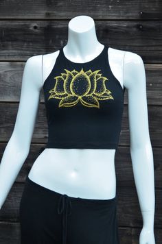 Gold Lotus Flower Fitted Crop Top - Women's Yoga Top - Festival Clothing This comfortable black fitted crop top features a double sided lotus flower design. The front has a large print in shinny metallic gold, and the back has a column of three smaller lotus flowers printed in glow in the dark. This Lotus flower is an original hand drawn image. The dark image shows the tank under a blacklight that is charging the glow in the dark ink.95% Cotton / 5% SpandexMade in the USAAvailable in sizes:SMALL Fitted Cropped Top For Yoga, Fitted Crop Tank Top For Yoga, Fitted Halter Crop Top For Yoga, Black Cropped Crop Top For Yoga, Fitted Cotton Tank Top For Yoga, Black Fitted Halter Top For Yoga, Festival Cropped Fitted Halter Top, Summer Yoga Crop Top, Festival Cotton Fitted Tops