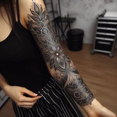 a woman with a black and grey tattoo on her arm