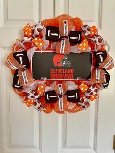 a wreath with footballs and bows on the front door for cleveland browns fanatics