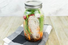 a mason jar filled with veggies and noodles