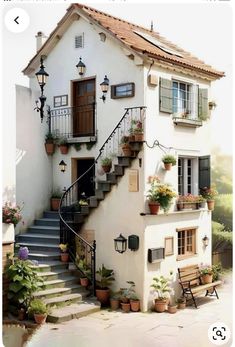 a white house with stairs and potted plants