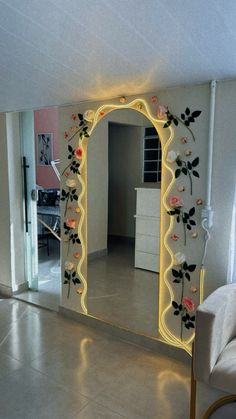 a mirror that is sitting on the floor in front of a wall with flowers painted on it