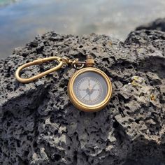 a gold pocket watch sitting on top of a rock