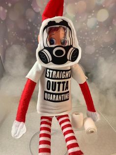 a red and white striped sock doll wearing a gas mask on it's head