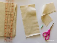 sewing supplies laid out next to each other on top of a white table with measuring tape and scissors