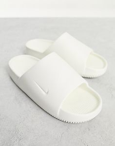 Shoes by Nike Slide into the szn Slip-on style Branded strap Open toe Chunky sole Nike Calm Slides Outfit, White Nike Slides, Realistic Wishlist, Jordan Slides, Shoes Wishlist, Slides Nike, School Soccer, Nike Slippers, Off White Shop