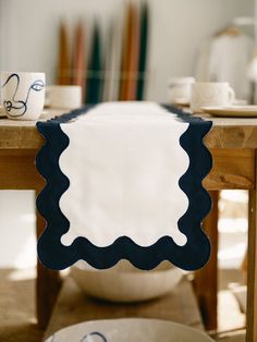 a table that has some plates and cups on it with a blue border around the edge