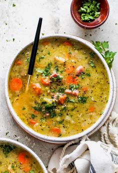 two bowls of soup with carrots and parsley