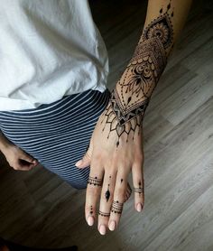 a woman's hand with hennap tattoos on her left arm and wrist