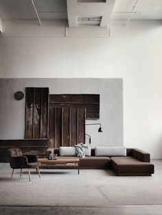 a living room with couches, tables and lamps on the wall next to each other