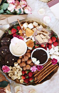 a platter filled with cookies, crackers, strawberries and other food items