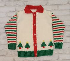 a knitted christmas cardigan with trees on the front and red, white, green, and yellow stripes