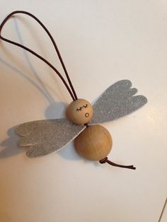 a wooden bead angel ornament sitting on top of a white countertop