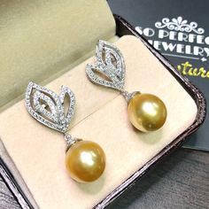 We are presenting you A PAIR OF matching SOUTH SEA PEARLS with LUSTROUS GOLDEN color. SET IN HANDCRAFTED, 18K SOLID GOLD DROP EARRINGS. ACCENTED WITH 116 E/VS, SPARKLING ROUND BRILLIANT DIAMONDS! IN CASE OF RETURN FOR US BUYERS. BUYERS MAY SEND THE ITEMS BACK TO OUR US-BASED OFFICE IN SALT LAKE CITY, UTAH ONLY ONE ITEM AVAILABLE!! NO DUPLICATES!! WHAT YOU SEE IN THE PICTURES IS WHAT YOU WILL GET SOLIDLY HANDCRAFTED EARRINGS! SUGGESTED RETAIL VALUE: $9,880 PEARLS: Size: 12 x 11 mm Shape: Oval/Rou Yellow Gold Drop Bridal Earrings For Formal Occasions, Formal Yellow Gold Drop Bridal Earrings, Luxury Yellow Gold Teardrop Bridal Earrings, Gold Pear-shaped Diamond Pearl Earrings, Gold Pear Shaped Diamond Pearl Earrings, Luxury Gold Pear-shaped Earrings, Luxury Yellow Earrings For Wedding, Luxury Pear-shaped Bridal Earrings For Party, Elegant Gold Pear-shaped Bridal Earrings