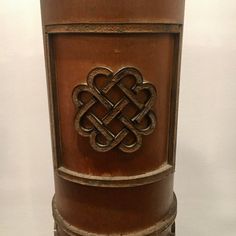 a wooden vase with an intricate design on it