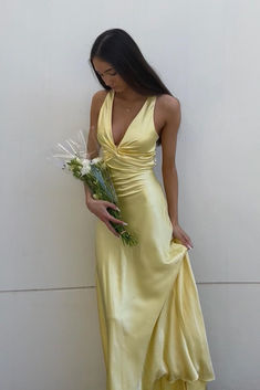 The v-neck satin party dress features a yellow color, soft material, and A-line silhouette. The front is twisted and the back crosses with a bow, creating an elegant look. This dress is full length and perfect for any occasion. SKU: 3894 Yellow color Soft satin material A-line silhouette Twist front with a v neck Cross cross with a bow in the back Full length Yellow Satin Prom Dress, Yellow Formal Dress, Simple Prom Dress Long, Dress Hire, Prom Dresses Yellow, Floor Length Prom Dresses, Prom Dress Stores, Prom Inspo, Yellow Satin