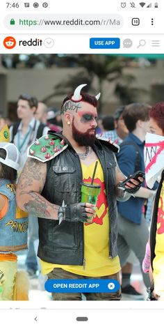 a man with tattoos and piercings on his face standing next to a woman in a yellow shirt