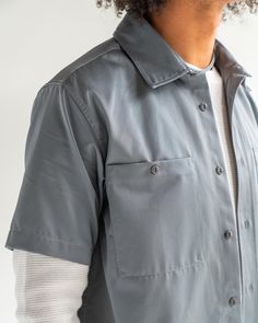 Solid Utility Top With Button Closure, Utility Style Short Sleeve Relaxed Fit Shirt, Utility Button-up Tops With Side Pockets, Utility Workwear Tops With Side Pockets, Utility Camp Collar Tops For Workwear, Everyday Utility Shirt With Button Closure, Utility Short Sleeve Tops With Button Closure, Gray Shirt With Pockets For Work, Utility Cotton Tops With Buttons