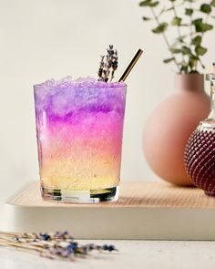 a purple and yellow drink sitting on top of a wooden tray