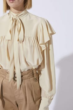 Ruffled, loose blouse from Laurence Bras with a small high collar and a neckline with a bow. It has long sleeves with cuffs closed with a button and stitched pleats at the chest. COMPOSITION: 100% CDC silk Romantic Blouses, Blouse Neck, Pretty Blouses, Loose Blouse, Woven Top, Neck Ruffle, Shakira, High Collar, Fashion Tops