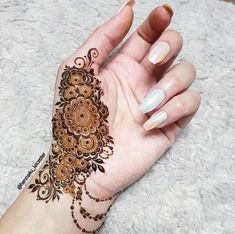 a woman's hand with a henna tattoo on it