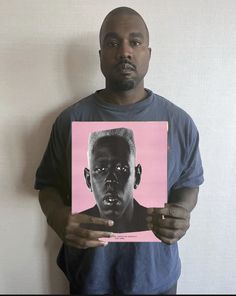 a man is holding up a pink and black photo with an image of him on it