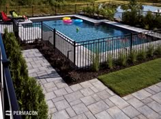 an above ground swimming pool surrounded by landscaping